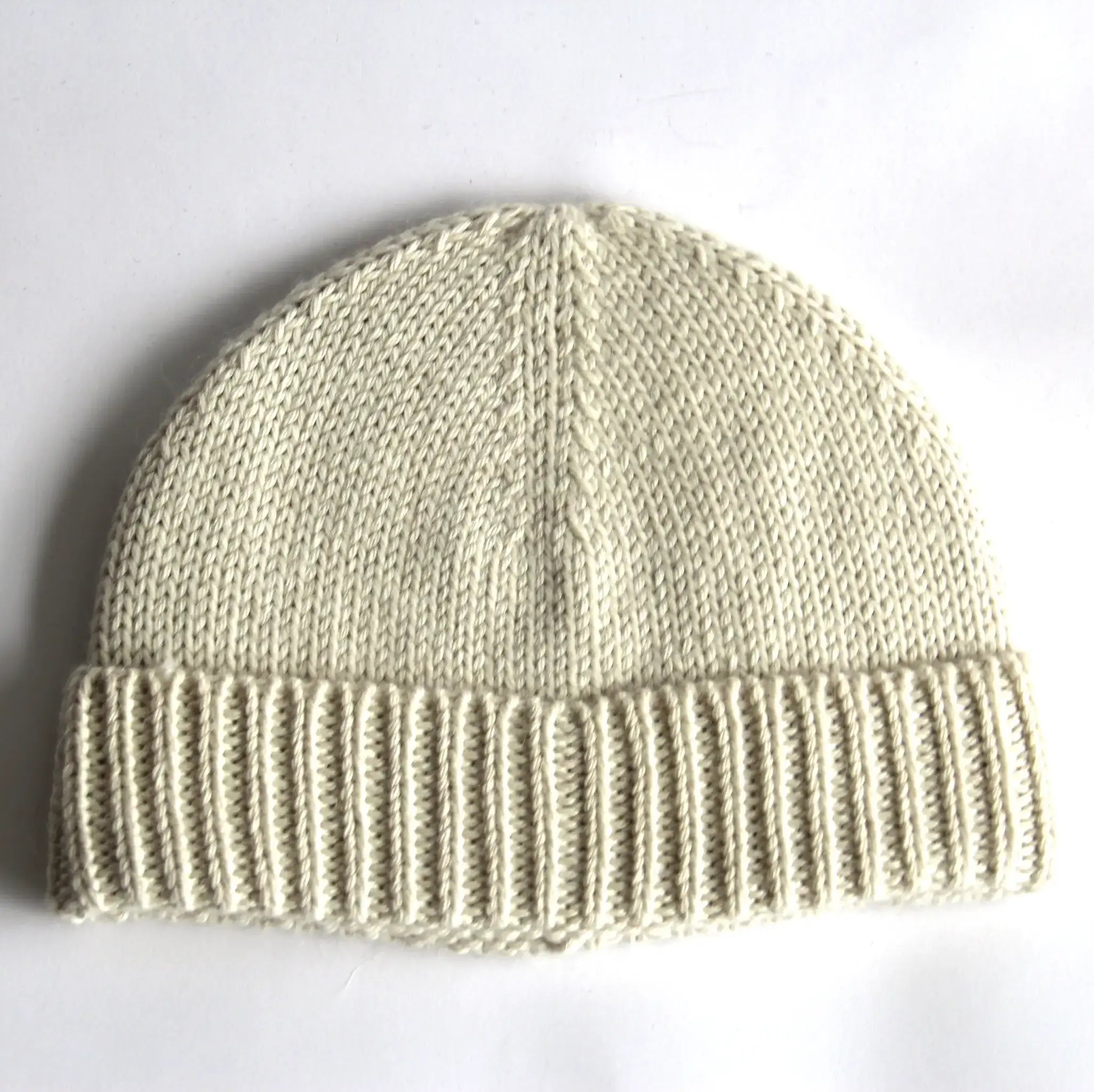 Close-up of a cream baby alpaca knitted beanie on a white background