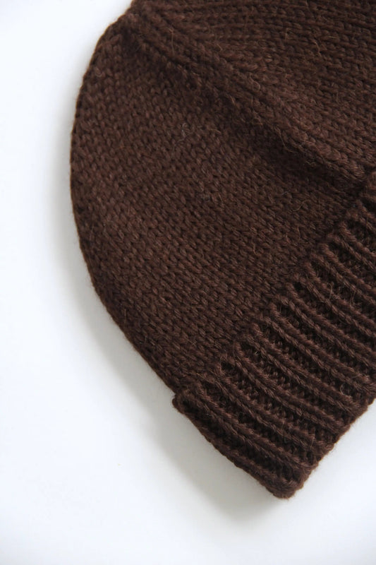 Close-up of a brown baby alpaca knitted beanie on a white background