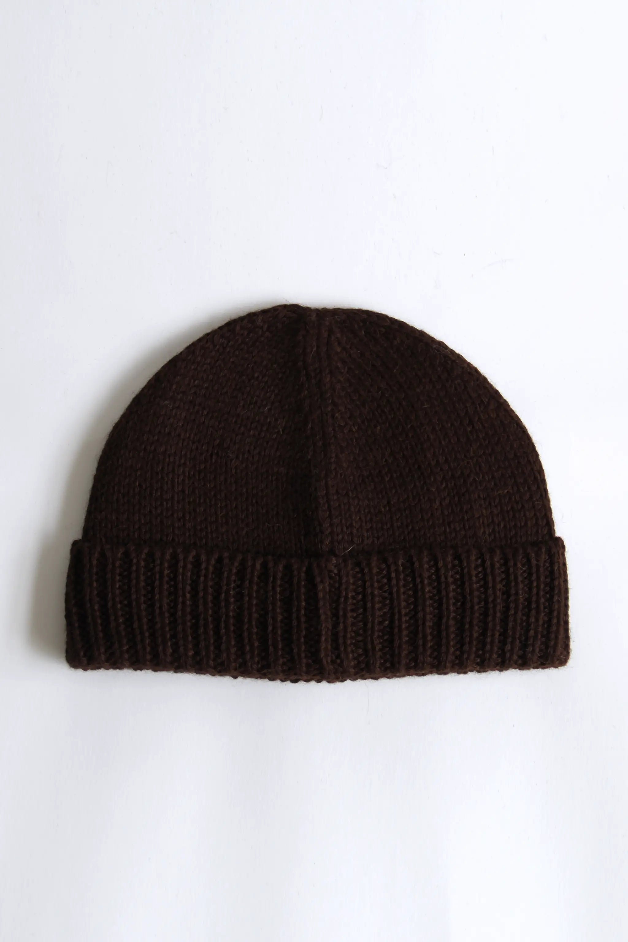 Close-up of a brown baby alpaca knitted beanie on a white background