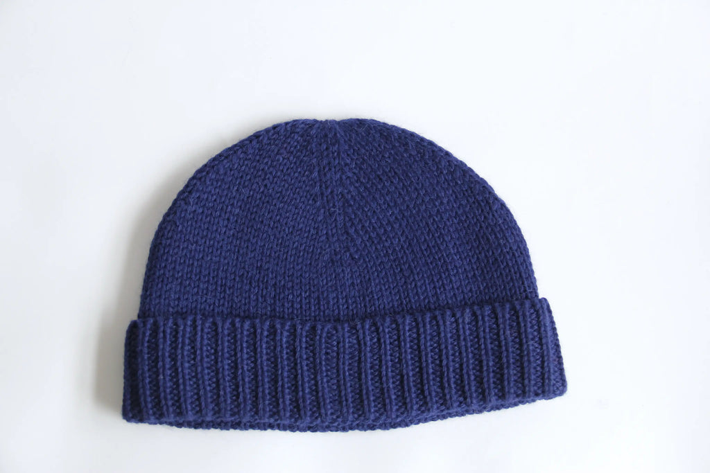 A blue 100% baby alpaca beanie on a white background