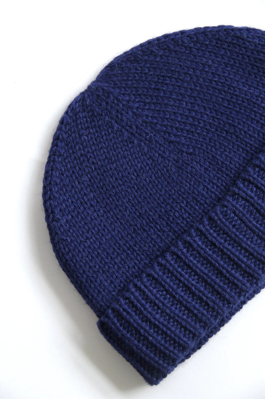 Close-up of a blue baby alpaca knitted beanie on a white background