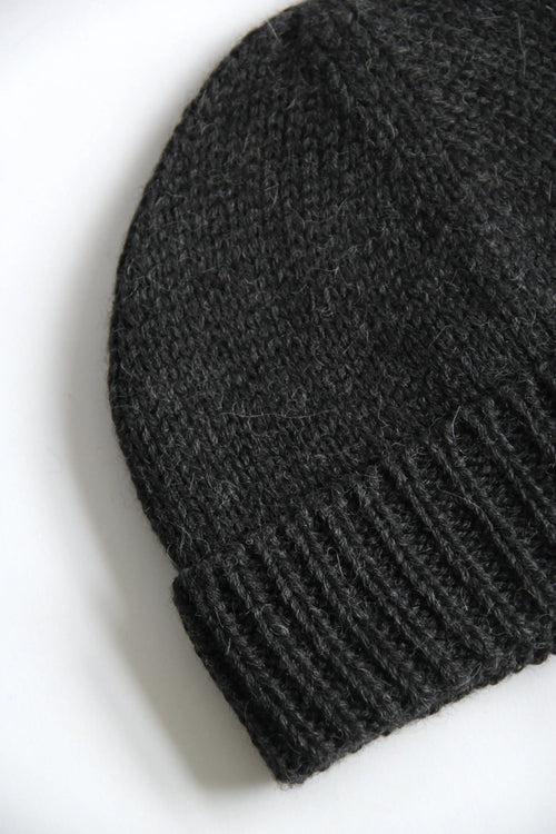 Close-up of a lead grey baby alpaca knitted beanie on a white background