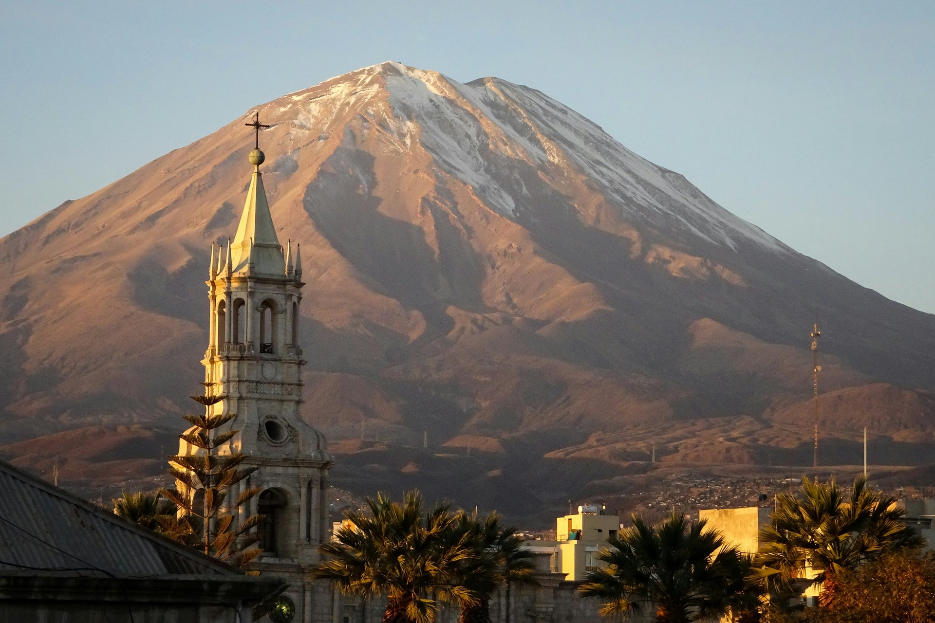 Church spire of Basilica Cathedral of Arequipa in the foreground with the volcano Misti in the background